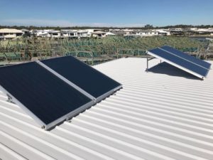 Solar hot water panels installed on a metal roof in Caboolture