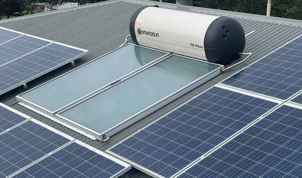 Solar hot water system mounted on a metal roof alongside PV panels in Caboolture